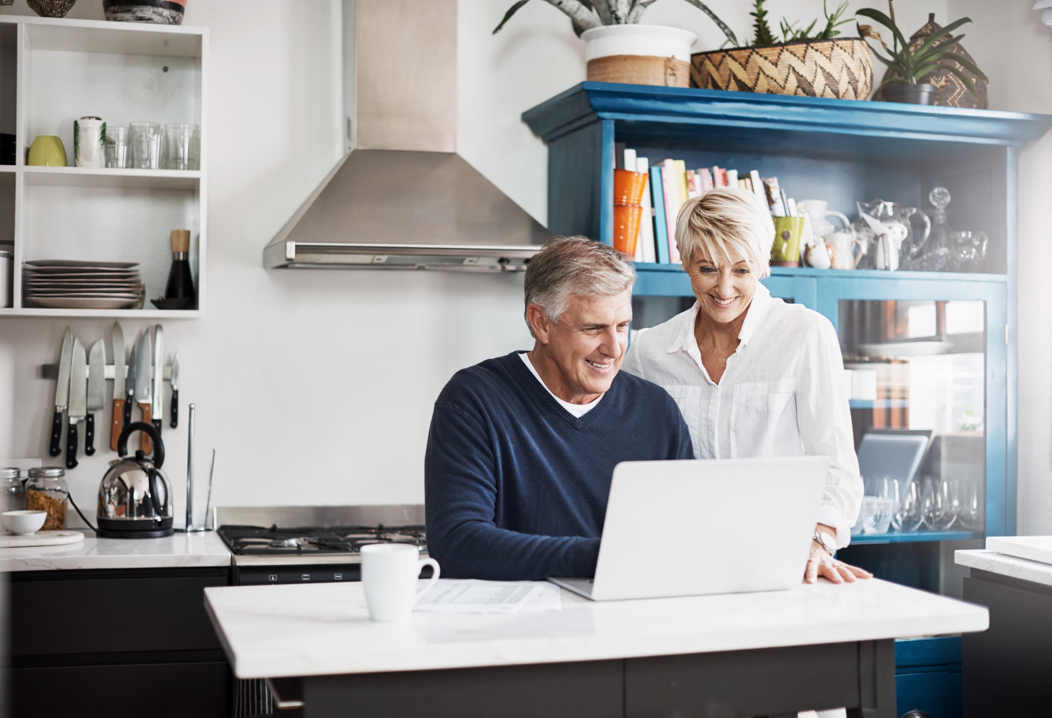 Shot of a mature couple using their laptop while bonding at home
